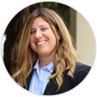 Portrait of a smiling woman in a business suit with a tree in the background