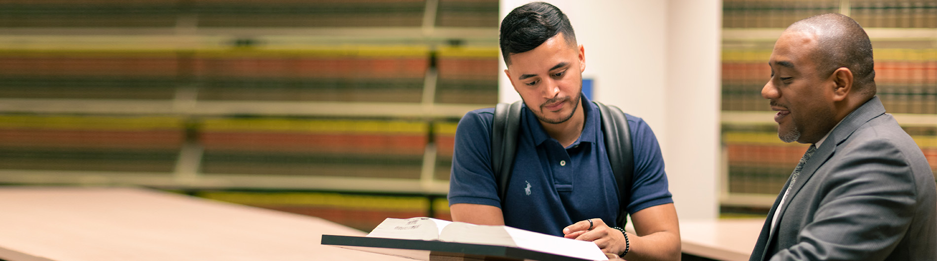 student and law professor reviewing a textbook together