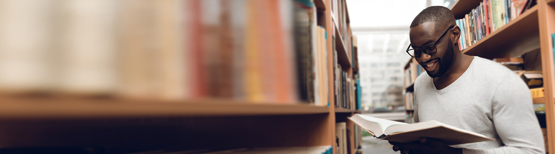 Young man holding book in libraray