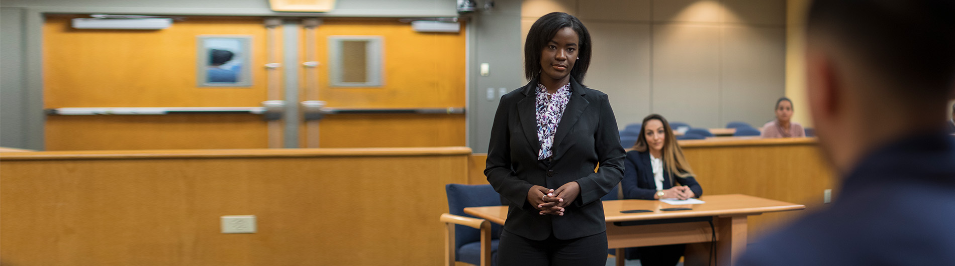 woman in business suit talking in courtroom