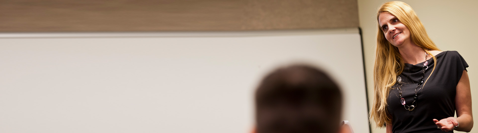 woman in front of classroom smiling