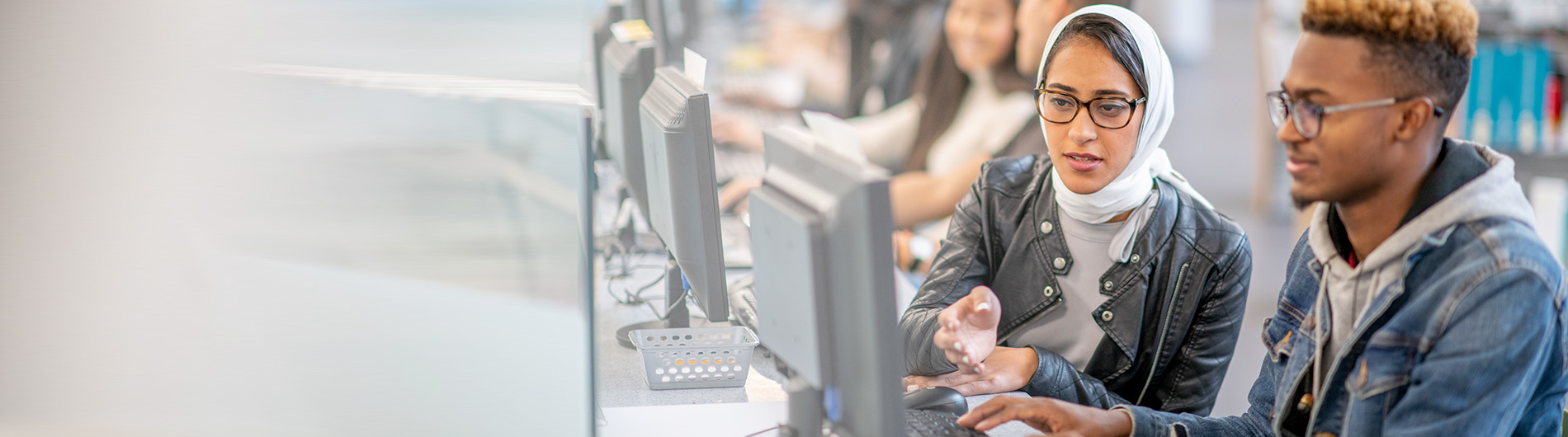 young woman and man in front of computer