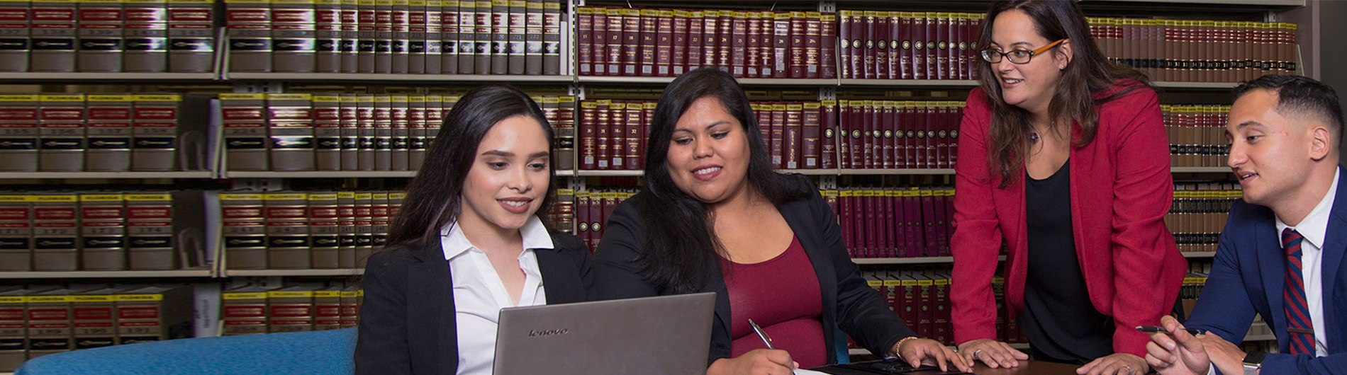 law students seated in a law library and studying texts