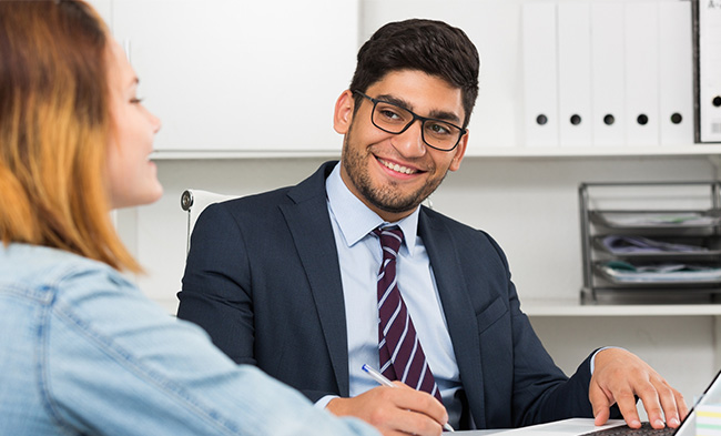 graduate student in suit smiling and taking notes