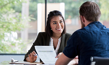 woman in business suit talking with student