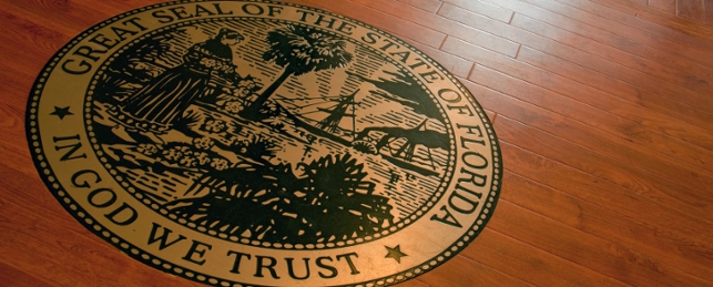Gold and black Florida State Seal imprinted on a wooden floor