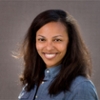 Portrait of smiling woman in blue shirt with gray background