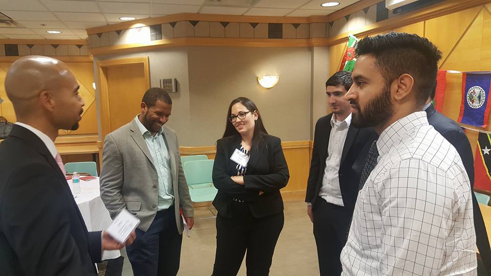 Group of adults standing in a circle and having a conversation indoors