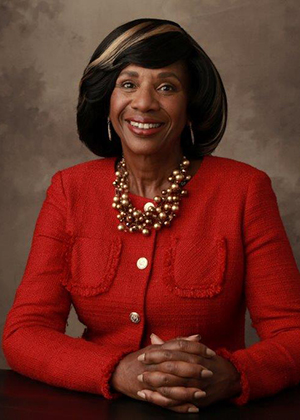 Portrait of a smiling woman in a red suit on a brown background