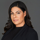 Portrait of a woman dressed in black on a gray background