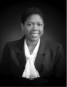Black and white portrait of a woman in a pinstripe suit on a gray background
