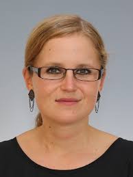 Portrait of a woman wearing a black blouse on a gray background